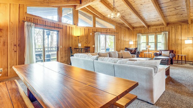A wooden cabin interior with a large dining table, a sofa, and a chandelier. - Treehouse-style Cabin, 1 Mi to Massanutten Resort (McGaheysville)