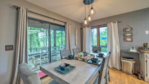Un espace repas comprenant une grande table, des chaises et une vue sur l’extérieur.