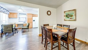 A dining area with a wooden table and chairs, a clock on the wall, and a painting above the table. - 33 Miles to Yosemite Park Entrance (Mariposa)