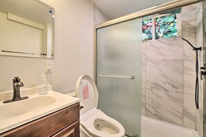 Een badkamer met toilet, wastafel en douche.