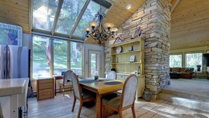 Una cocina amplia con una pared de acento de piedra, una mesa de comedor de madera y sillas.