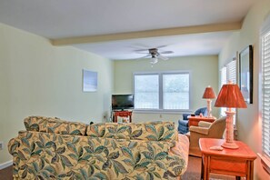 A living room with a sofa, a television, and two lamps.