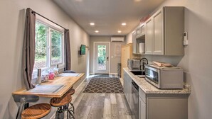 Una cocina compacta con comedor, microondas y refrigerador.