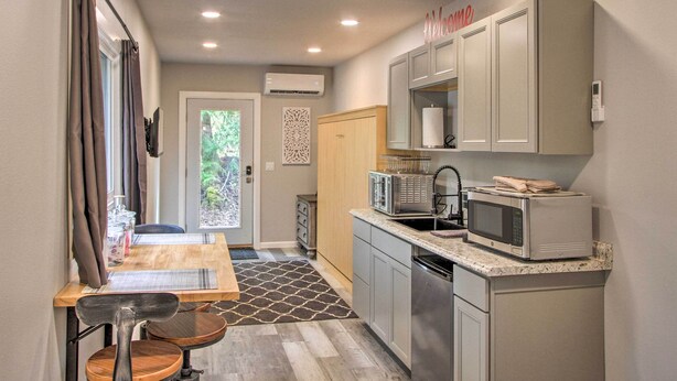 A compact kitchen with a dining area, a microwave, and a small refrigerator. - Steps to Foothills Trail: Unique Carbonado Studio (Carbonado)