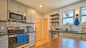 Una cocina con electrodomésticos de acero inoxidable, armarios de madera y un salpicadero con diseño.