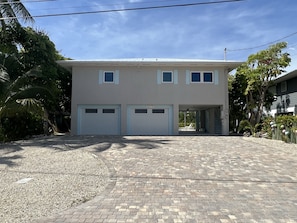 A two-story house with a garage, a paved driveway, and a well-maintained lawn.