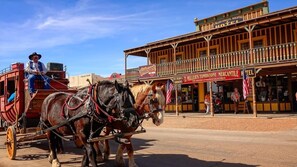 A horse-drawn carriage in front of a hotel with a balcony and a sign that reads "MILLER'S TOMBSTONE MERCANTILE HOTEL". - Spacious & Private Sierra Vista Retreat with Pool! (Sierra Vista)