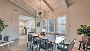 A spacious dining area with a large table, modern chairs, and a unique chandelier. - Creekside Chalet With Deck < 7 Miles to Ski! (Maggie Valley)