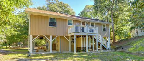 A two-story house with a covered porch and a staircase leading to an upper level.