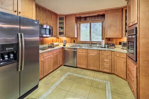 A kitchen with wooden cabinets, stainless steel appliances, a microwave, toaster, and a dishwasher. - Near Hiking: Home w/ Trout Stream in Bakersville! (Bakersville)