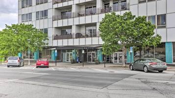 A multi-story hotel with a modern facade, outdoor seating, and a parking area.