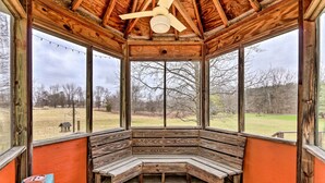 A wooden gazebo with a bench, large windows, and a ceiling fan. - 5-acre Vacation Home w/ Woods & Hiking Ground (Pickerington)
