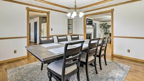 A dining room with a large table, six chairs, and a patterned rug. - 5-acre Vacation Home w/ Woods & Hiking Ground (Pickerington)