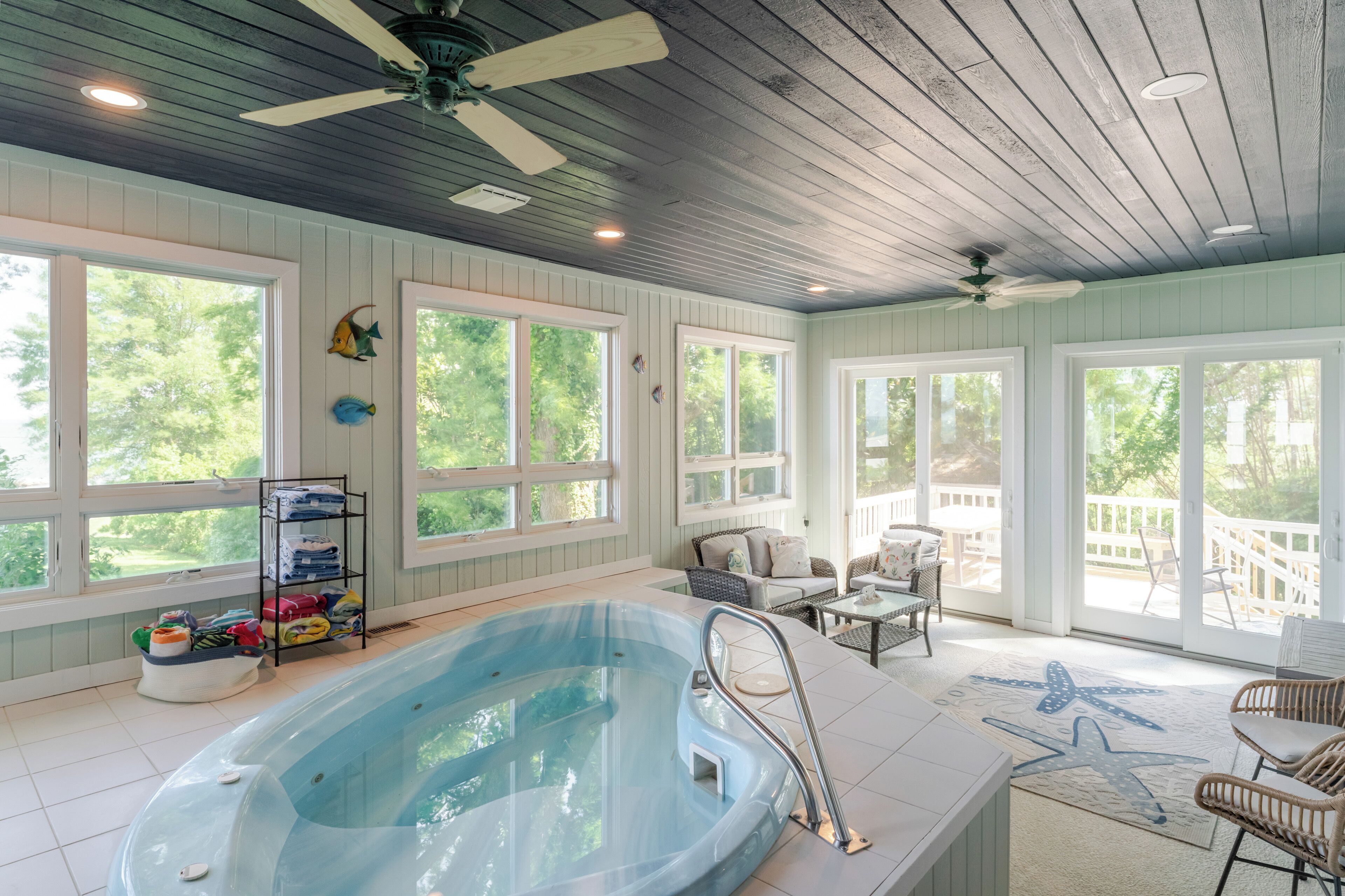 A spa area with a hot tub, seating, and large windows.