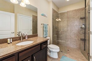 A bathroom with a double sink vanity, a toilet, and a glass-enclosed shower. - Lakefront Paradise With Stunning Views! (Corsicana)