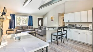 Um espaço de estar moderno com área de refeições, cozinha e zona de estar.