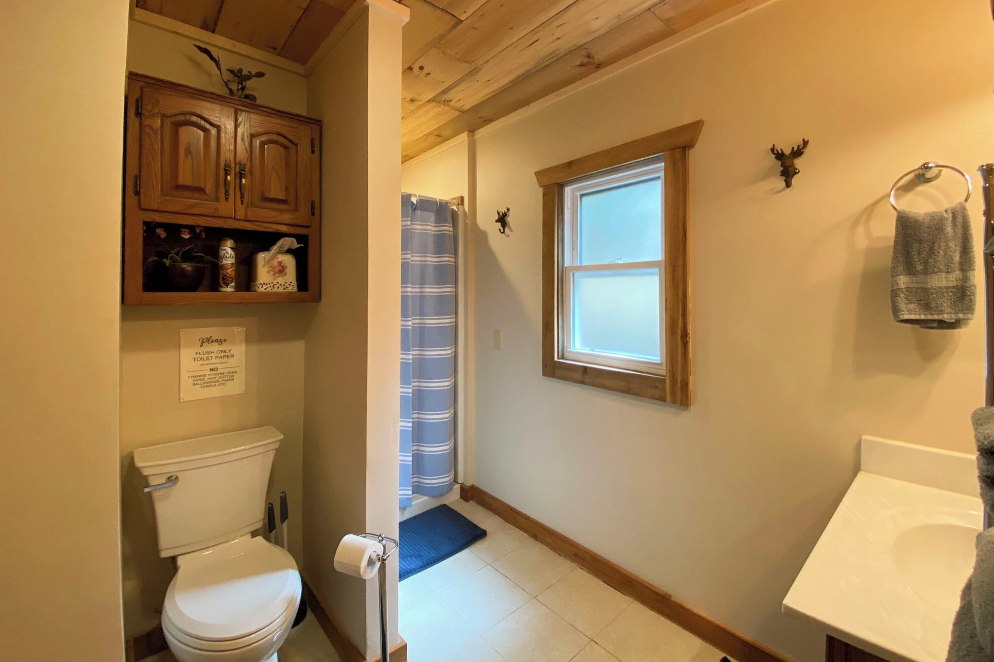 Un baño pequeño con inodoro, lavamanos y cortina de ducha.