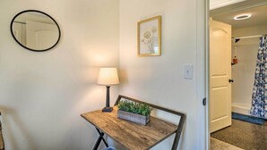 A room with a wooden desk, a round mirror, a framed picture, a lamp, and a small plant. - Cañon City Home: 15 Mi to Royal Gorge Bridge! (Canon City)