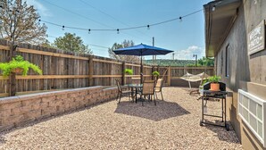 A patio area with a table and chairs, a blue umbrella, and a barbecue grill. - Cañon City Home: 15 Mi to Royal Gorge Bridge! (Canon City)