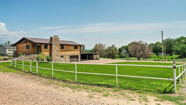 A stable with a stone chimney, a fenced riding area, and a wooden building with a garage. - Cañon City Home: 15 Mi to Royal Gorge Bridge! (Canon City)