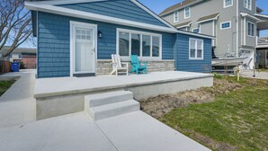 A two-story house with a front porch, a garage, and a small yard.