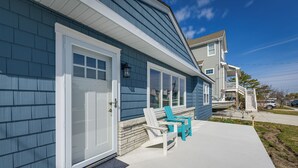 A house with a front porch, a door, and two chairs.
