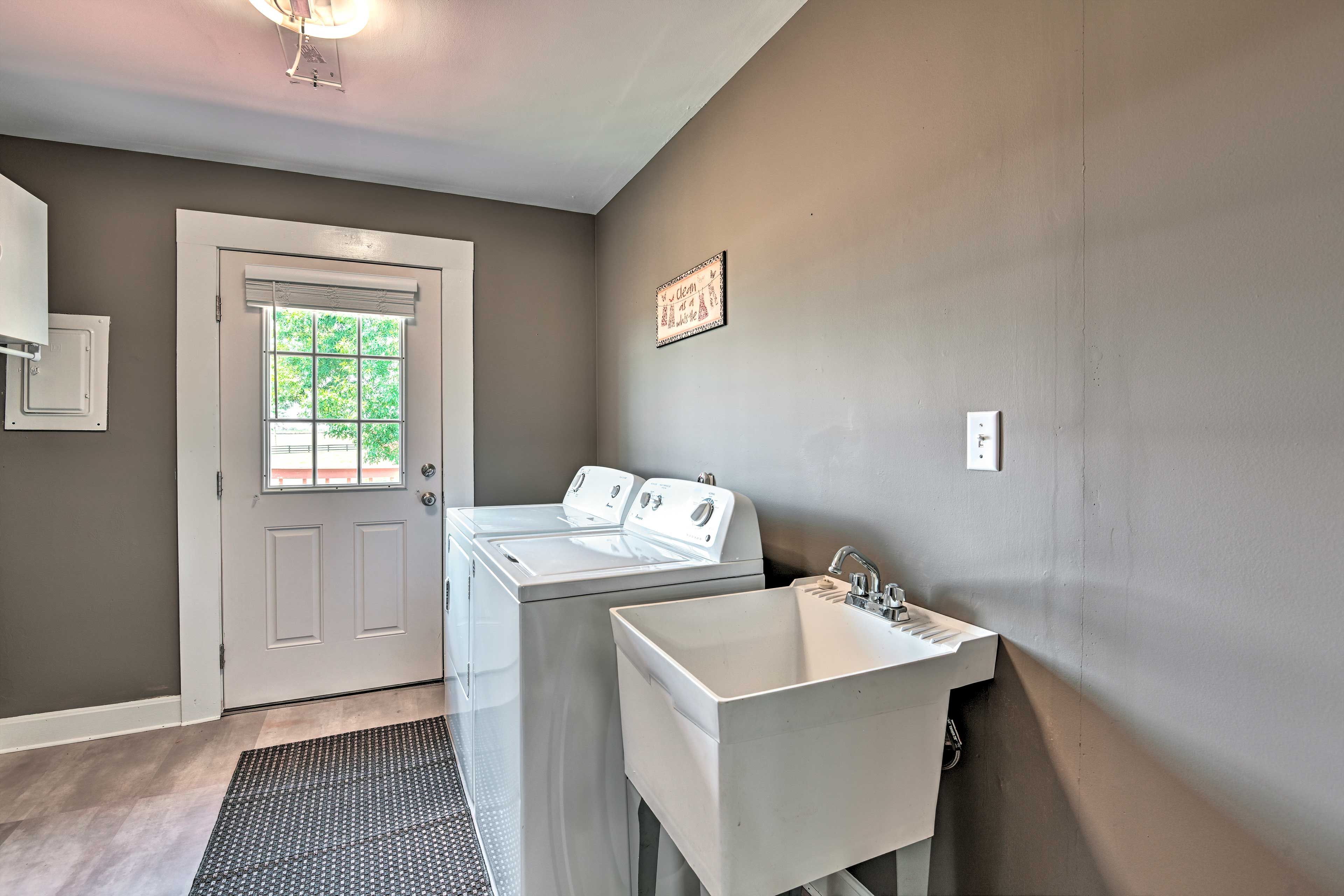 A laundry room with a washing machine, dryer, and sink.