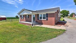 A single-story brick house with a covered porch and a small front yard.
