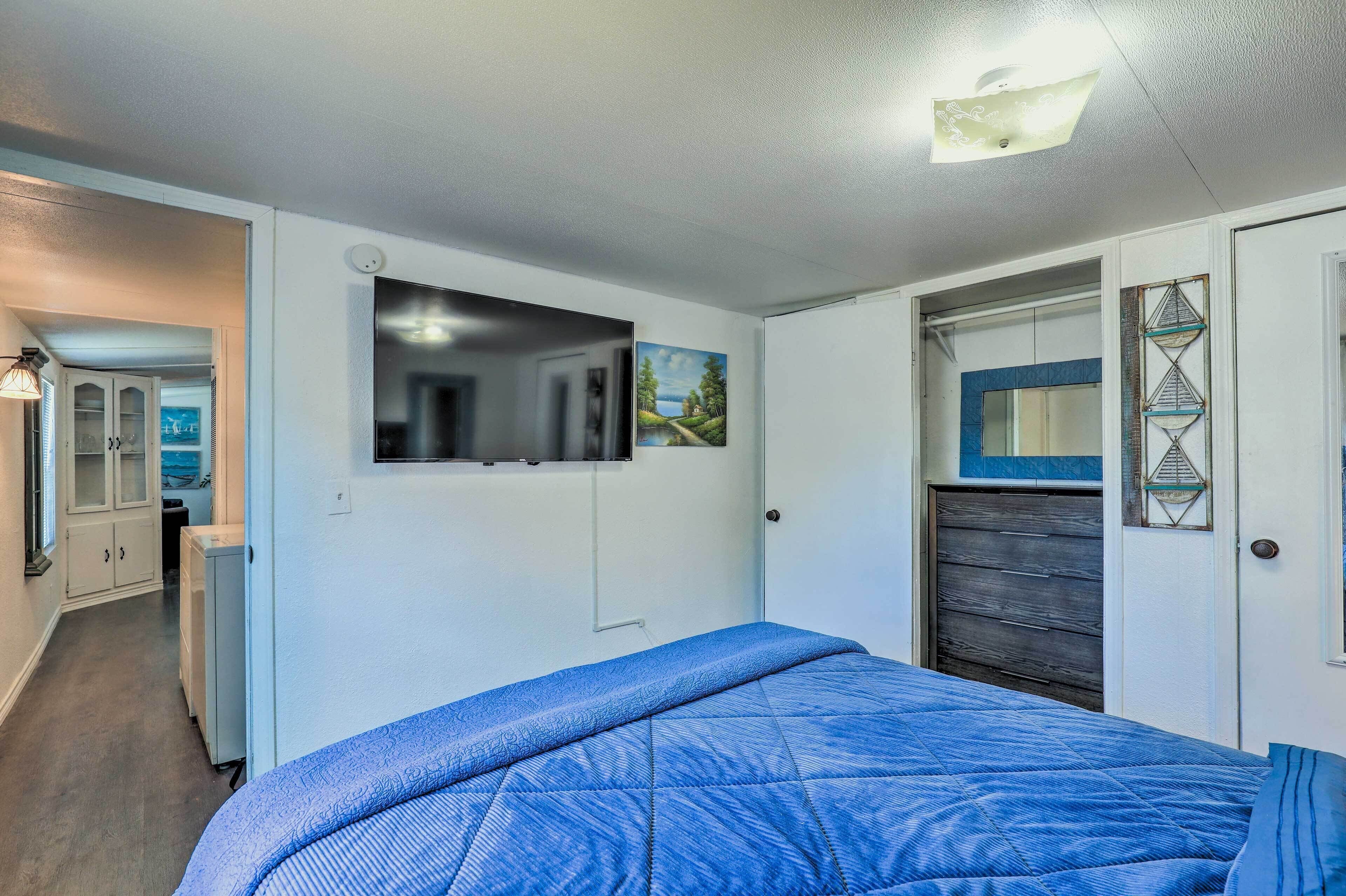 A bedroom with a bed, a wardrobe, a mirror, and a door with a decorative frame.