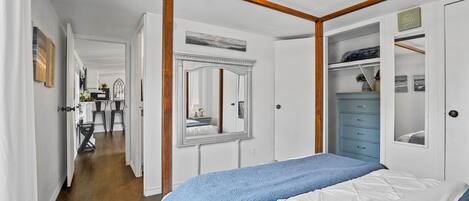 A bedroom with a large bed, a wardrobe, and a mirror.