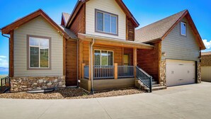 A two-story house with a stone foundation, a porch, and a garage. - Private Beach Access! Luxe 7BR Bear Lake Cabin (Garden City)