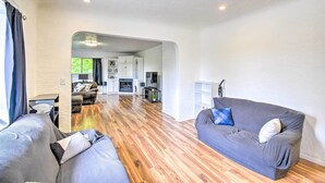 Ein modernes Wohnzimmer mit grauem Sofa, gestreiftem Sofa und Holzboden.