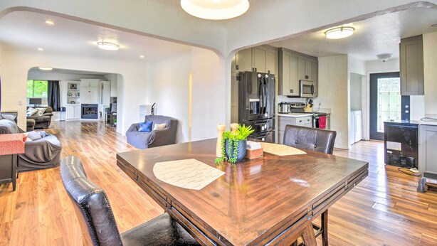 Ein geräumiges Wohnzimmer mit einem großen Esstisch aus Holz, bequemen Sitzgelegenheiten und einer Küchenzeile mit modernen Geräten.