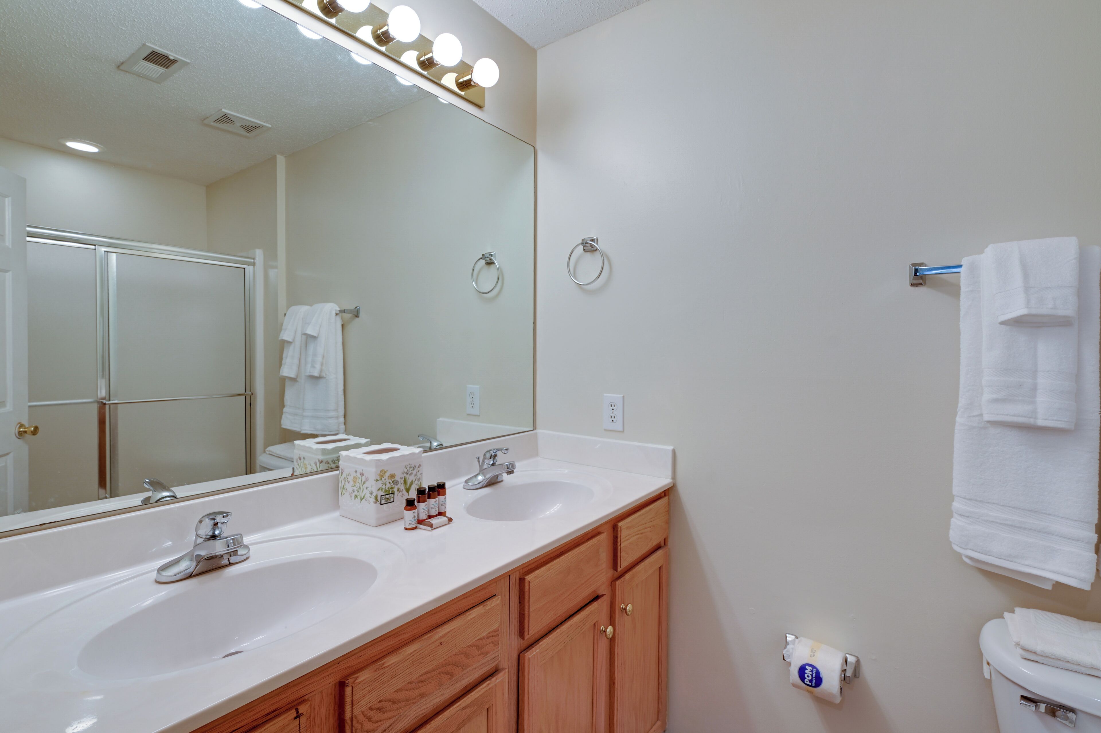 A bathroom with two sinks, a large mirror, and a towel rack.
