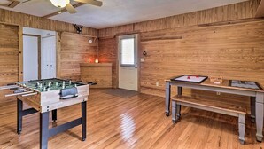 Ein Raum mit Holzwänden, einem Kicker, einem rollbaren Kicker, einer Bank und einem Tisch mit einem Brettspiel.