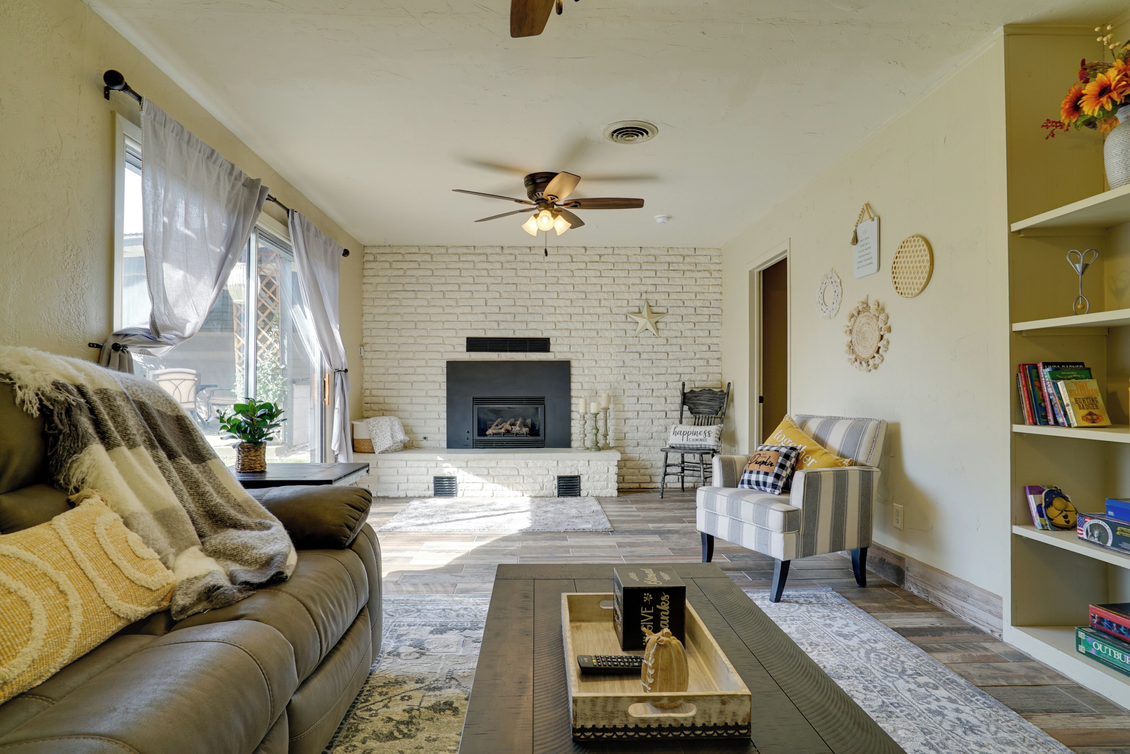 A living room with a fireplace, a sofa, a coffee table, and a bookshelf.