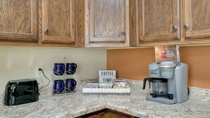 A kitchen with wooden cabinets, a coffee maker, a toaster, and a sign that reads "Coffee Time". - Chic Silver City Getaway w/ Patio + Gas Grill (Silver City)