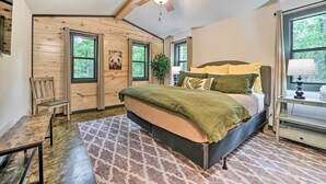 A bedroom with a bed, a chair, a desk, and a window. - Quiet & Peaceful Hochatown Cabin w/ Hot Tub! (Broken Bow)