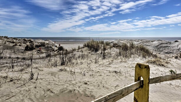 A beach with sand dunes and a wooden fence. - Coastal Condo w/ Pool, 1 Block to Wildwood Beach! (North Wildwood)