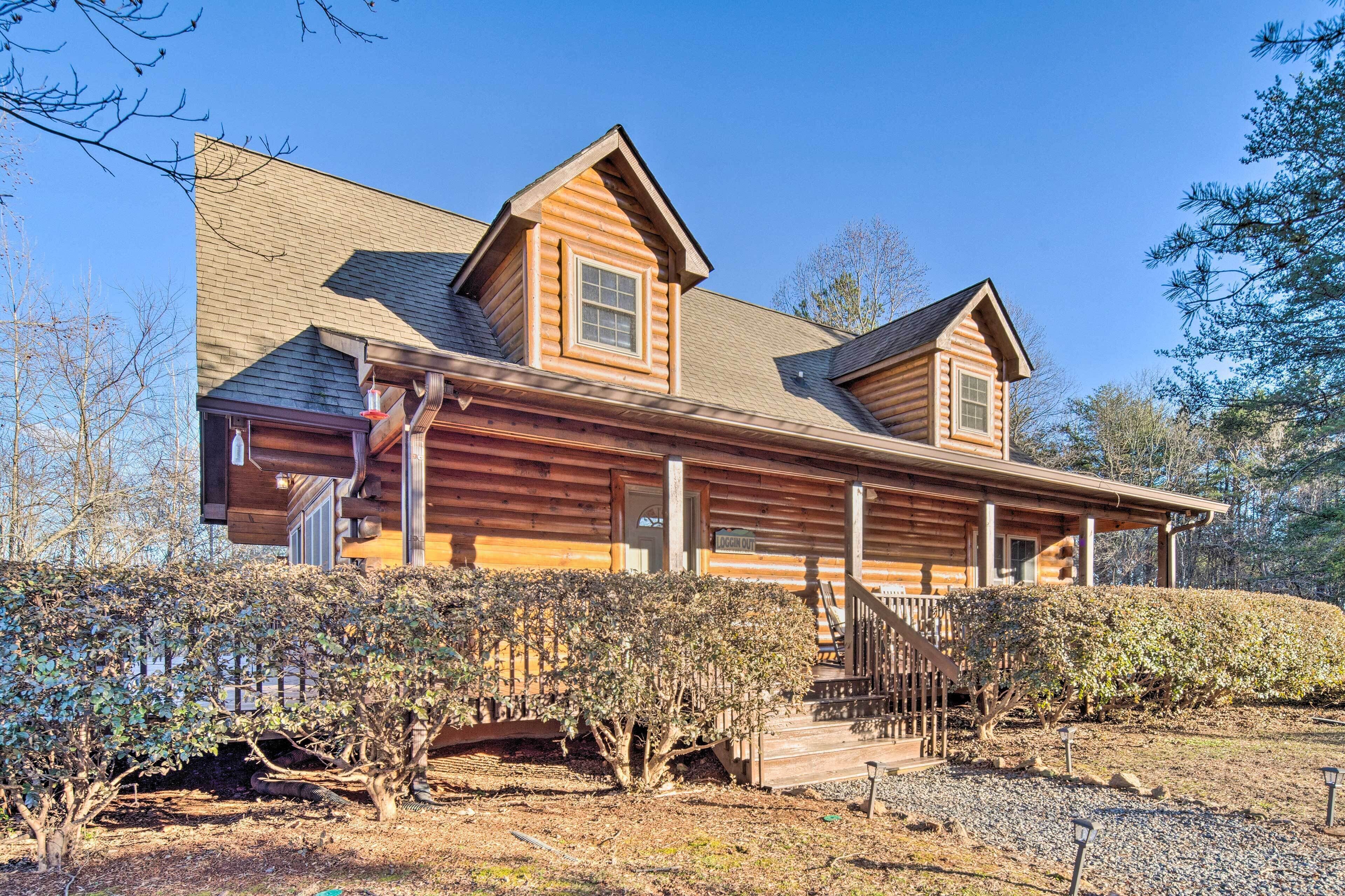A log cabin with a steeply pitched roof, a front porch, and a covered front entrance.