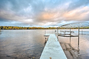 A wooden dock extending into a calm lake with a forest in the background. - Cozy Hayward Cottage w/ Dock & Lakefront View (Hayward)