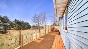 A wooden deck with a view of trees and a building with blue siding. - Charming Wisconsin Getaway w/ Nearby Lake! (Pound)