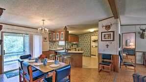 A spacious kitchen with wooden cabinets, a central island, and a dining area with a large table and chairs. - Spacious Utopia Family Home w/ Hill Country Views (Utopia)