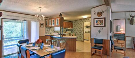A spacious kitchen with wooden cabinets, a central island, and a dining area with a large table and chairs.