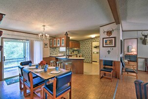 Una cocina amplia con armarios de madera, una isla central y un comedor con una mesa grande y sillas.