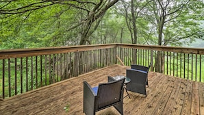 A wooden deck with wicker furniture and a view of a forest. - 7 Mi to Lake Harmony: Home w/ Furnished Deck! (Albrightsville)