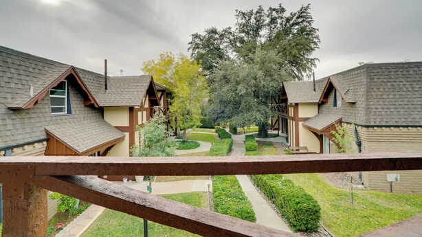 Zona residencial con varias casas, un camino central y un árbol grande.