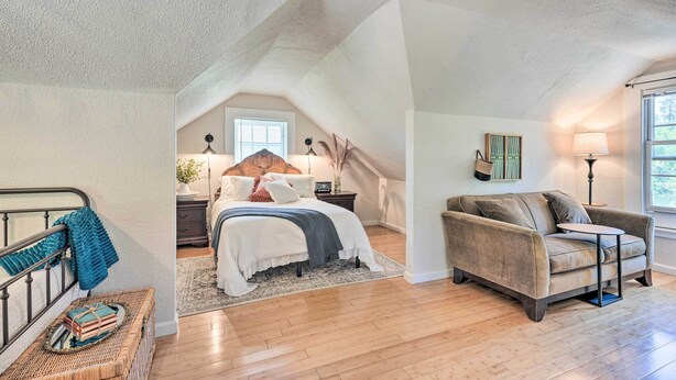 A bedroom with a bed, a nightstand, a dresser, a chair, and a window.