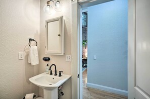 Une salle de bain avec un lavabo blanc, un miroir et un porte-serviettes.