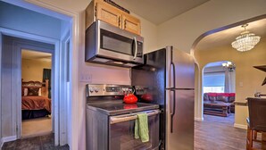A kitchen with a stainless steel oven, microwave, and refrigerator, wooden cabinets, and a chandelier. - Downtown Cedar City House < 1/2 Mi to SUU Campus! (Cedar City)